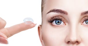 Verre de contact sur l'index près du beau visage femelle image libre de droits Verre de contact sur l'index près du beau visage femelle image libre de droits