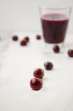 Verre de jus et de baies frais autour de lui sur la table blanche image libre de droits Verre de jus et de baies frais autour de lui sur la table blanche image libre de droits