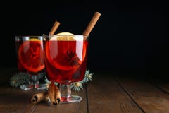 Verres avec du vin chaud rouge sur la table en bois sur le fond foncé image stock Verres avec du vin chaud rouge sur la table en bois sur le fond foncé image stock