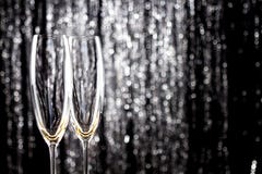 Verres vides de champagne ou de vin avec la décoration de tresse de Noël de scintillement sur le fond image stock Verres vides de champagne ou de vin avec la décoration de tresse de Noël de scintillement sur le fond image stock