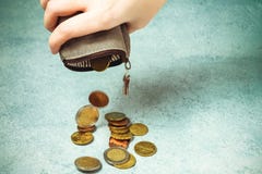 Verscheidene muntstukken vallen op de lijst van een lege portefeuille in de hand van een vrouw, armoede, crisis, faillissement en stock foto Verscheidene muntstukken vallen op de lijst van een lege portefeuille in de hand van een vrouw, armoede, crisis, faillissement en stock foto