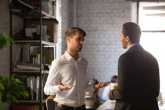 Verschiedener männlicher Firmenmitarbeiter, der im Büro und in der Unterhaltung steht lizenzfreies stockfoto Verschiedener männlicher Firmenmitarbeiter, der im Büro und in der Unterhaltung steht lizenzfreies stockfoto