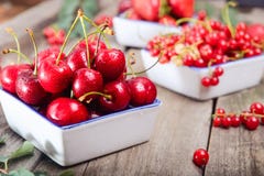 Verse de zomerbessen - aardbei, kers en rode stroom in ceramische kommen op de rustieke houten lijst De zomergezonde voeding Land Royalty-vrije Stock Afbeeldingen Verse de zomerbessen - aardbei, kers en rode stroom in ceramische kommen op de rustieke houten lijst De zomergezonde voeding Land Royalty-vrije Stock Afbeeldingen
