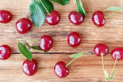 Verse kers met groene bladeren op houten achtergrond De achtergrond van het fruit stock afbeeldingen Verse kers met groene bladeren op houten achtergrond De achtergrond van het fruit stock afbeeldingen