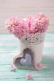 Verse roze hyacintenbloemen in emmer en decoratief hart stock foto Verse roze hyacintenbloemen in emmer en decoratief hart stock foto