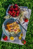 Top view on portion of cherry cake with ripe strawberries around and yellow blooms Royalty Free Stock Images Top view on portion of cherry cake with ripe strawberries around and yellow blooms Royalty Free Stock Images