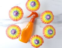 Sunscreen under the colorful beach umbrellas.Concept of sun protection during vacation, top view stock photography Sunscreen under the colorful beach umbrellas.Concept of sun protection during vacation, top view stock photography