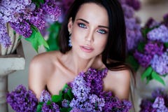Verticale de beauté Belle femme avec les lèvres sensuelles se reposant parmi les fleurs violettes Cosmétiques, maquillage parfume Images libres de droits Verticale de beauté Belle femme avec les lèvres sensuelles se reposant parmi les fleurs violettes Cosmétiques, maquillage parfume Images libres de droits