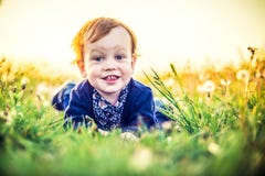 Very cute toddler smiling portrait in white dandelion meadow