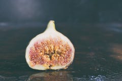 A very ripe blue fig on a dark background. Organic fruits. Healthy food royalty free stock photo A very ripe blue fig on a dark background. Organic fruits. Healthy food royalty free stock photo