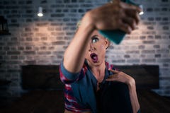 Very surprised young woman looking in camera of smartphone stock photo Very surprised young woman looking in camera of smartphone stock photo