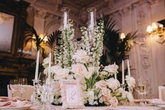 Verzierter eleganter Bankettisch in einer klassischen Art in der Villa Verziert mit Blumensträußen von weißen Blumen von den Rose lizenzfreies stockbild Verzierter eleganter Bankettisch in einer klassischen Art in der Villa Verziert mit Blumensträußen von weißen Blumen von den Rose lizenzfreies stockbild