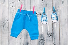 Vestiti del bambino che appendono sulla corda da bucato. immagine stock Vestiti del bambino che appendono sulla corda da bucato. immagine stock