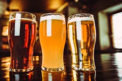 Vetri di birra leggera e scura su un fondo del pub immagini stock Vetri di birra leggera e scura su un fondo del pub immagini stock