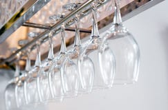 Vetri di vino alti vuoti che appendono nello scaffale sopra uno scaffale della barra nella ricerca fotografia stock Vetri di vino alti vuoti che appendono nello scaffale sopra uno scaffale della barra nella ricerca fotografia stock