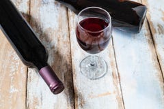 Vetro di vino e bottiglia di vino su vecchio fondo di legno immagini stock Vetro di vino e bottiglia di vino su vecchio fondo di legno immagini stock