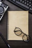 Vetro sul libro sullo scrittorio del lavoro immagini stock Vetro sul libro sullo scrittorio del lavoro immagini stock