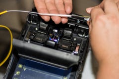 Vezel optische kabel die door ingenieur met van het het Lasapparaatinstrument van de Optische Vezelfusie de professionele machine stock afbeeldingen Vezel optische kabel die door ingenieur met van het het Lasapparaatinstrument van de Optische Vezelfusie de professionele machine stock afbeeldingen