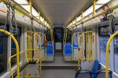 Viaje en tranvía dentro, interior del transporte de la ciudad con las manijas azules del amarillo de los asientos, las luces bril fotografía de archivo Viaje en tranvía dentro, interior del transporte de la ciudad con las manijas azules del amarillo de los asientos, las luces bril fotografía de archivo