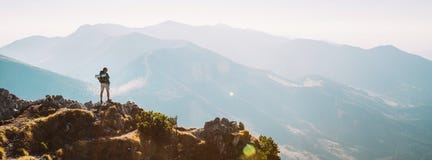 Viandante della montagna con il soggiorno minuscolo della figurina dello zaino sul picco di montagna con bello panorama fotografie stock libere da diritti Viandante della montagna con il soggiorno minuscolo della figurina dello zaino sul picco di montagna con bello panorama fotografie stock libere da diritti