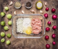 Viande hachée crue avec de la farine et des oignons dans un bol en verre avec des herbes, des pousses et le radis sur la fin rust photo stock Viande hachée crue avec de la farine et des oignons dans un bol en verre avec des herbes, des pousses et le radis sur la fin rust photo stock
