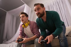 Video game concept, father and son enjoying playing console together. Stock Images Video game concept, father and son enjoying playing console together. Stock Images