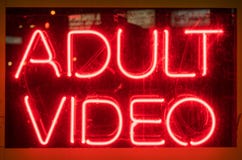 Video segno adulto al neon rosso illuminato su esposizione immagine stock libera da diritti Video segno adulto al neon rosso illuminato su esposizione immagine stock libera da diritti