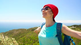 3 in 1 video. Woman with a backpack behind her back gives her hand to her companion, standing on top of a hill on the stock video 3 in 1 video. Woman with a backpack behind her back gives her hand to her companion, standing on top of a hill on the stock video