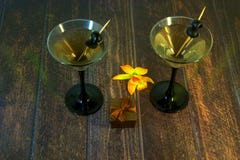 Vidrio de Martini con las aceitunas con la caja de regalo y la orquídea amarilla en una tabla de madera foto de archivo Vidrio de Martini con las aceitunas con la caja de regalo y la orquídea amarilla en una tabla de madera foto de archivo
