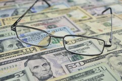 Vidrios en el dinero del dólar, concepto financiero foto de archivo libre de regalías Vidrios en el dinero del dólar, concepto financiero foto de archivo libre de regalías