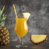 Vidro do suco de abacaxi com frutos frescos no bacground cinzento imagens de stock royalty free Vidro do suco de abacaxi com frutos frescos no bacground cinzento imagens de stock royalty free