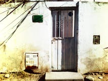 Vieille porte grise de tôle dans un mur usé images libres de droits Vieille porte grise de tôle dans un mur usé images libres de droits