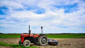 Viejo trabajo del tractor sobre el campo imagenes de archivo Viejo trabajo del tractor sobre el campo imagenes de archivo