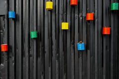 Viele malten bunte leere Dosen wiederverwendet als Blumentöpfe, angebracht zur schwarzen Metallwand stockfoto Viele malten bunte leere Dosen wiederverwendet als Blumentöpfe, angebracht zur schwarzen Metallwand stockfoto