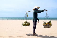 VIETNAM, Mui Ne - 27 BRENGEN 2017 in de war De verkoper die van het strandfruit op het strand in Vietnam lopen Hij verkoopt kokos royalty-vrije stock afbeeldingen VIETNAM, Mui Ne - 27 BRENGEN 2017 in de war De verkoper die van het strandfruit op het strand in Vietnam lopen Hij verkoopt kokos royalty-vrije stock afbeeldingen