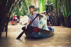 Vietnamesische Leute auf tragenden Touristen eines kleinen Holzschiffs lizenzfreies stockfoto Vietnamesische Leute auf tragenden Touristen eines kleinen Holzschiffs lizenzfreies stockfoto