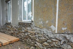 Vieux mur endommagé d'une maison de sabre avec une base s'effondrante de la maison photographie stock libre de droits Vieux mur endommagé d'une maison de sabre avec une base s'effondrante de la maison photographie stock libre de droits
