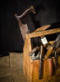 Vieux outils utilisés dans la boîte à outils Fond foncé Éclairage de tache Cadre en bois d'isolement photographie stock libre de droits Vieux outils utilisés dans la boîte à outils Fond foncé Éclairage de tache Cadre en bois d'isolement photographie stock libre de droits