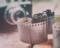 Vieux petits pains de film de photo, cassette et rétro appareil-photo images stock Vieux petits pains de film de photo, cassette et rétro appareil-photo images stock