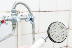 Vieux pommeau de douche sale ?troit avec le limescale et le m?langeur de douche et les tuiles calcifi?s et rouill?s de moule sur photos stock Vieux pommeau de douche sale ?troit avec le limescale et le m?langeur de douche et les tuiles calcifi?s et rouill?s de moule sur photos stock