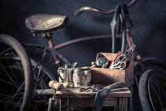 Vieux service de difficulté de vélo avec les roues, la correction en caoutchouc et les outils photographie stock Vieux service de difficulté de vélo avec les roues, la correction en caoutchouc et les outils photographie stock