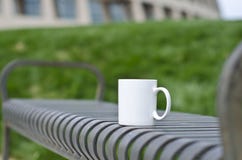 A blank white coffee mug on the park bench royalty free stock images A blank white coffee mug on the park bench royalty free stock images