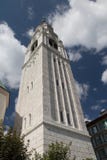 Blue sky with clouds behind white belfry church of Cortina d`Ampezzo, Veneto, Italy. Royalty Free Stock Photography Blue sky with clouds behind white belfry church of Cortina d`Ampezzo, Veneto, Italy. Royalty Free Stock Photography