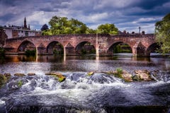 View of Devorgilla Bridge with river flowing over rocks stock image View of Devorgilla Bridge with river flowing over rocks stock image