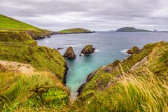 High cliffs on beautiful coastline with rocky islands in a distance, moody dark sky with stormy clouds royalty free stock photo High cliffs on beautiful coastline with rocky islands in a distance, moody dark sky with stormy clouds royalty free stock photo