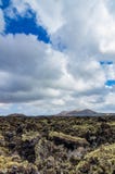 View over a lava field on Lanzarote with volcanoes in the background Royalty Free Stock Photos View over a lava field on Lanzarote with volcanoes in the background Royalty Free Stock Photos