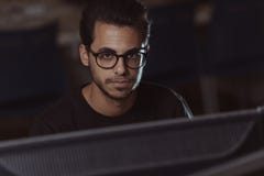 View over a screen of the face of a young computer science student working with the computer. stock image View over a screen of the face of a young computer science student working with the computer. stock image