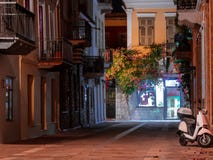 View of a streetin Nafplio, Greece, at night decorated by flowers and vines and parked scooter stock photos View of a streetin Nafplio, Greece, at night decorated by flowers and vines and parked scooter stock photos