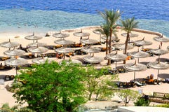 View from the top to a beautiful sandy beach with sun loungers, sun beds and sun umbrellas on vacation in a tropical warm exotic c stock photos View from the top to a beautiful sandy beach with sun loungers, sun beds and sun umbrellas on vacation in a tropical warm exotic c stock photos