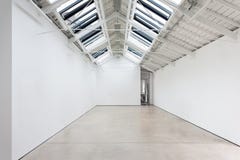 A view of a white painted interior of an empty room or an art gallery with a skylight lighting and concrete floors royalty free stock photography A view of a white painted interior of an empty room or an art gallery with a skylight lighting and concrete floors royalty free stock photography